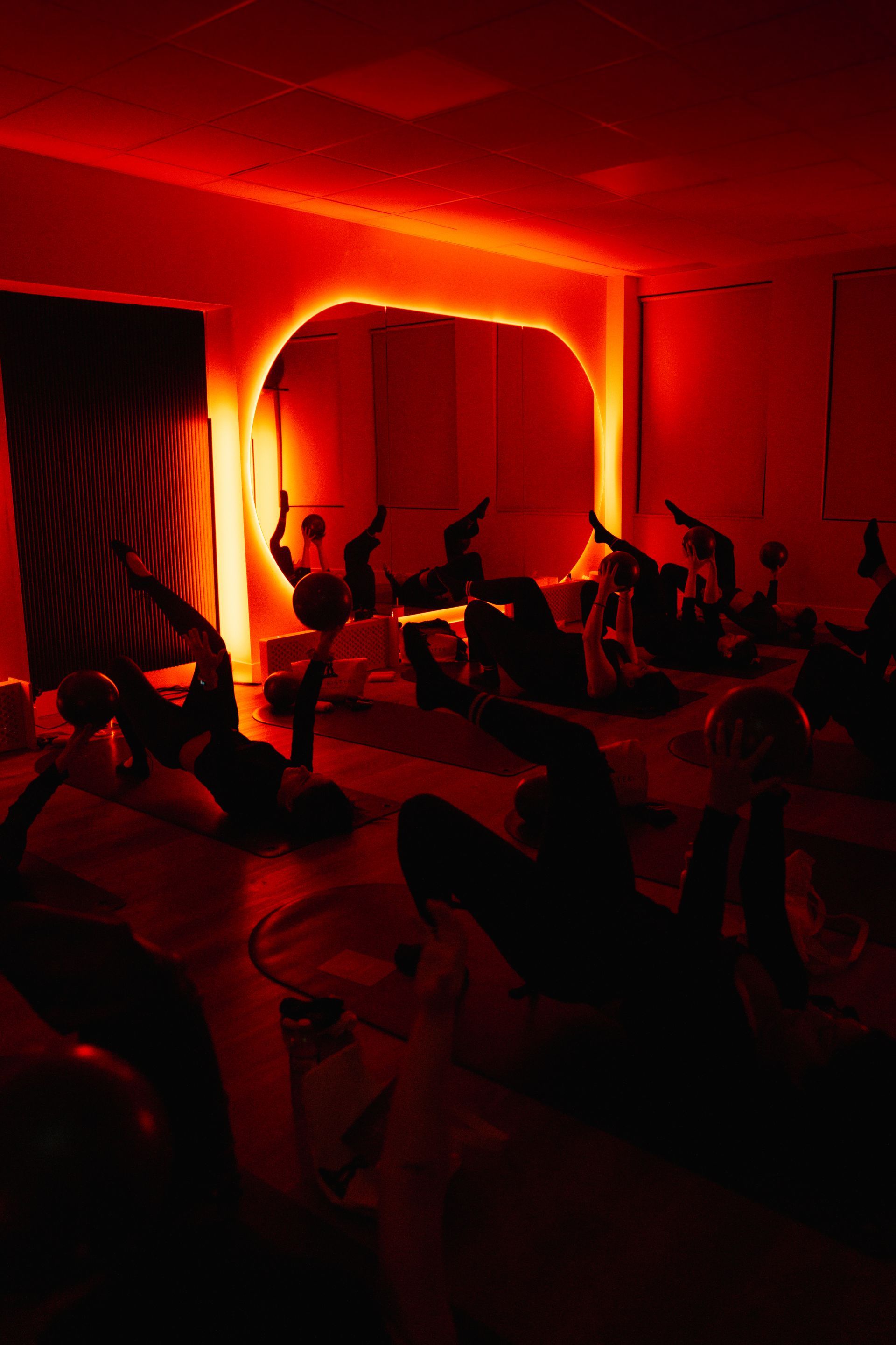 Group mat Pilates class with red light therapy at Two Sisters Pilates in Oakville